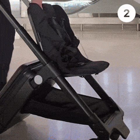 Dad at airport folding up TernX Carry On Suitcase Stroller