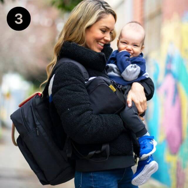 Mom carrying stylish black backpack diaper bag